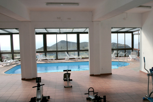 The covered pool and bordering fitness area